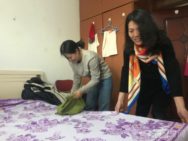 王岩(左)与同事一起收拾新家。 邵铖 摄