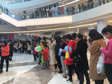 围观的群众或是驻足观赏，或是排队领取晚安定制抱枕和3月11日的樱花节门票，好不热闹！