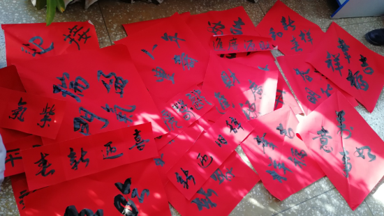不一会，周边的地上、桌上便摆起了大师们写就的一副副春联，