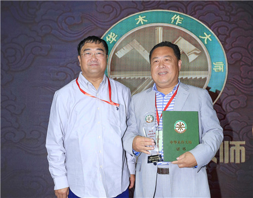 中华文化促进会常务副秘书长陈钢（左）为夏振南（右）颁授“中华木作大师”荣誉