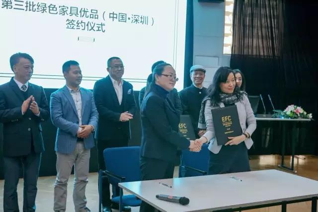 红苹果家具运营行政总监王梅林（前排左一）与深圳家协秘书长洪小惠（前排右一）签订《绿色家具优品质量承诺责任书》