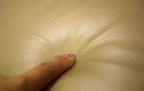 用手指按压沙发软包，真皮表面能看到独特的细纹。