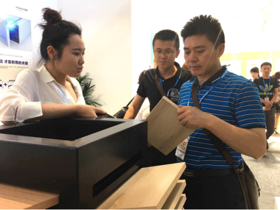 司米橱柜3D镭射板引爆北京国际家居展(图7) (观展者在了解司米3D镭射板样板)