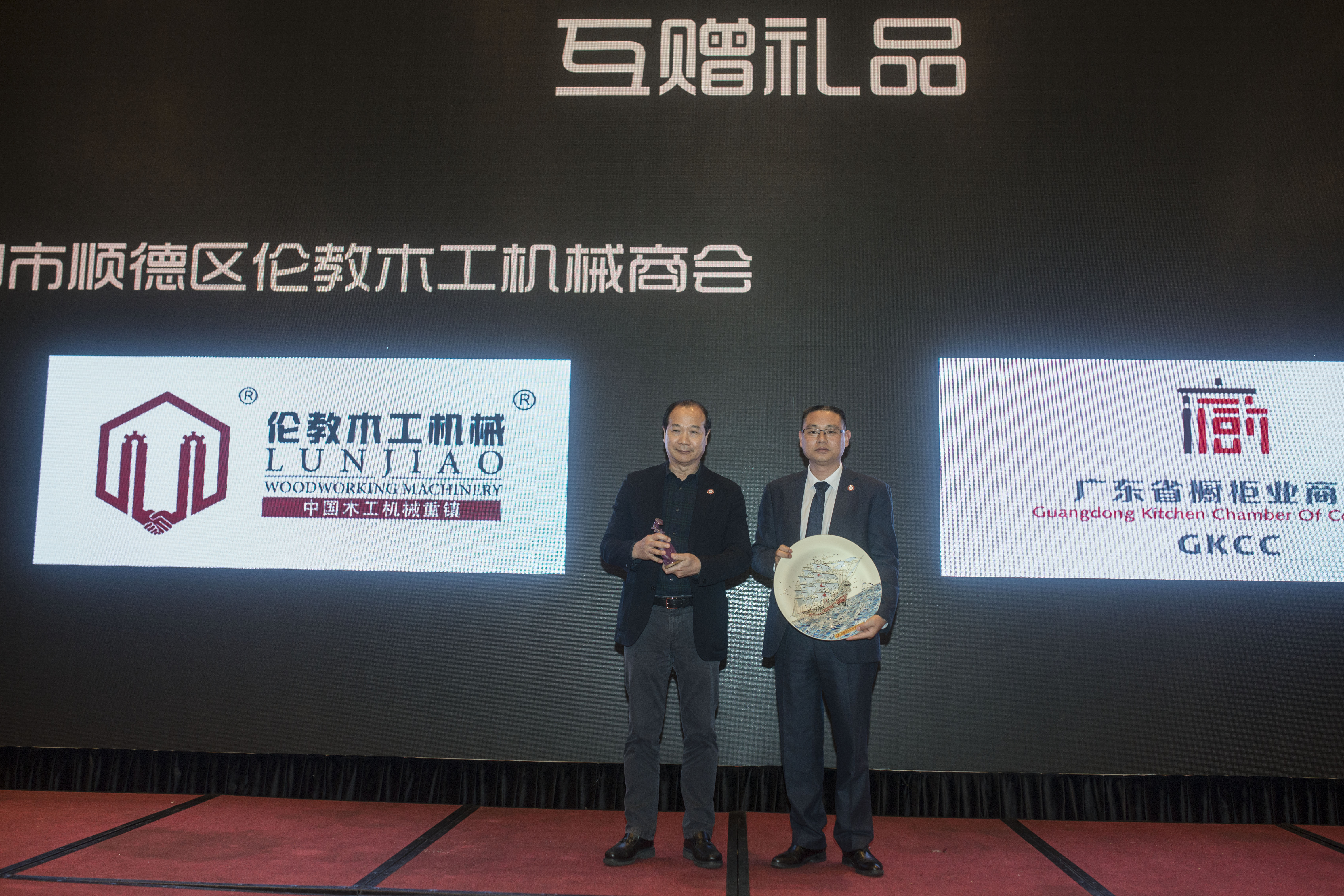 广东省橱柜业商会常务副会长胡双喜代表与佛山市顺德区伦教木工机械商会会长刘乐球互赠礼物