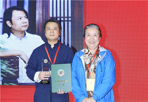 中华儿童艺术促进会会长范崇嬿（右）为石华久（左）颁授“中华木作大师”荣誉