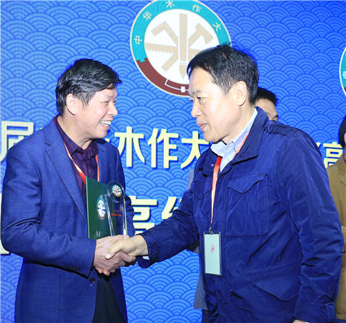 中华木工委专家委员会主任张德祥（右）为陈义仁（左）颁授“中华高级木作师”荣誉