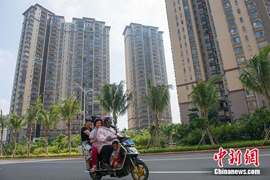 资料图:市民在海口市区某地产项目前路过。 <a target='_blank' href='http://www.chinanews.com/'>中新社</a>记者 骆云飞 摄 资料图:市民在海口市区某地产项目前路过。 <a target='_blank' href='http://www.chinanews.com/'>中新社</a>记者 骆云飞 摄