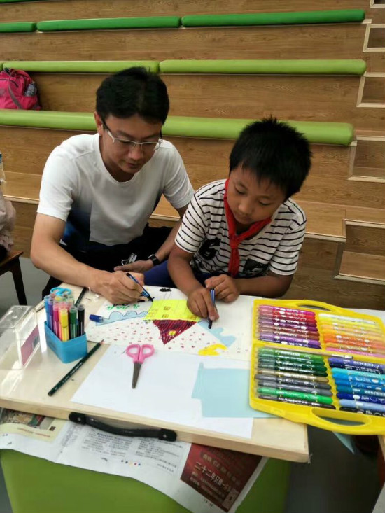▲殷艳明先生教孩子们画画