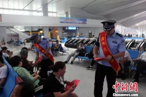 资料图：青岛铁路公安处民警向旅客发放安全宣传资料。　梁西征 摄