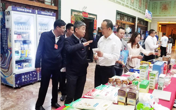 西藏德琴阳光庄园有限公司董事长张学斌（左三）向参会者介绍青稞产品