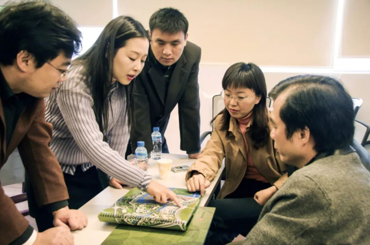 分管营销工作的陈茵与领导同事一起研究新楼盘规划方案